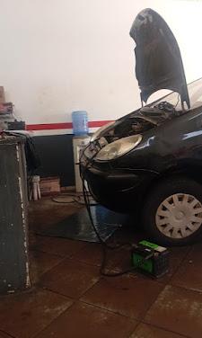 Veículo com capô aberto conectado a equipamento de diagnóstico na oficina